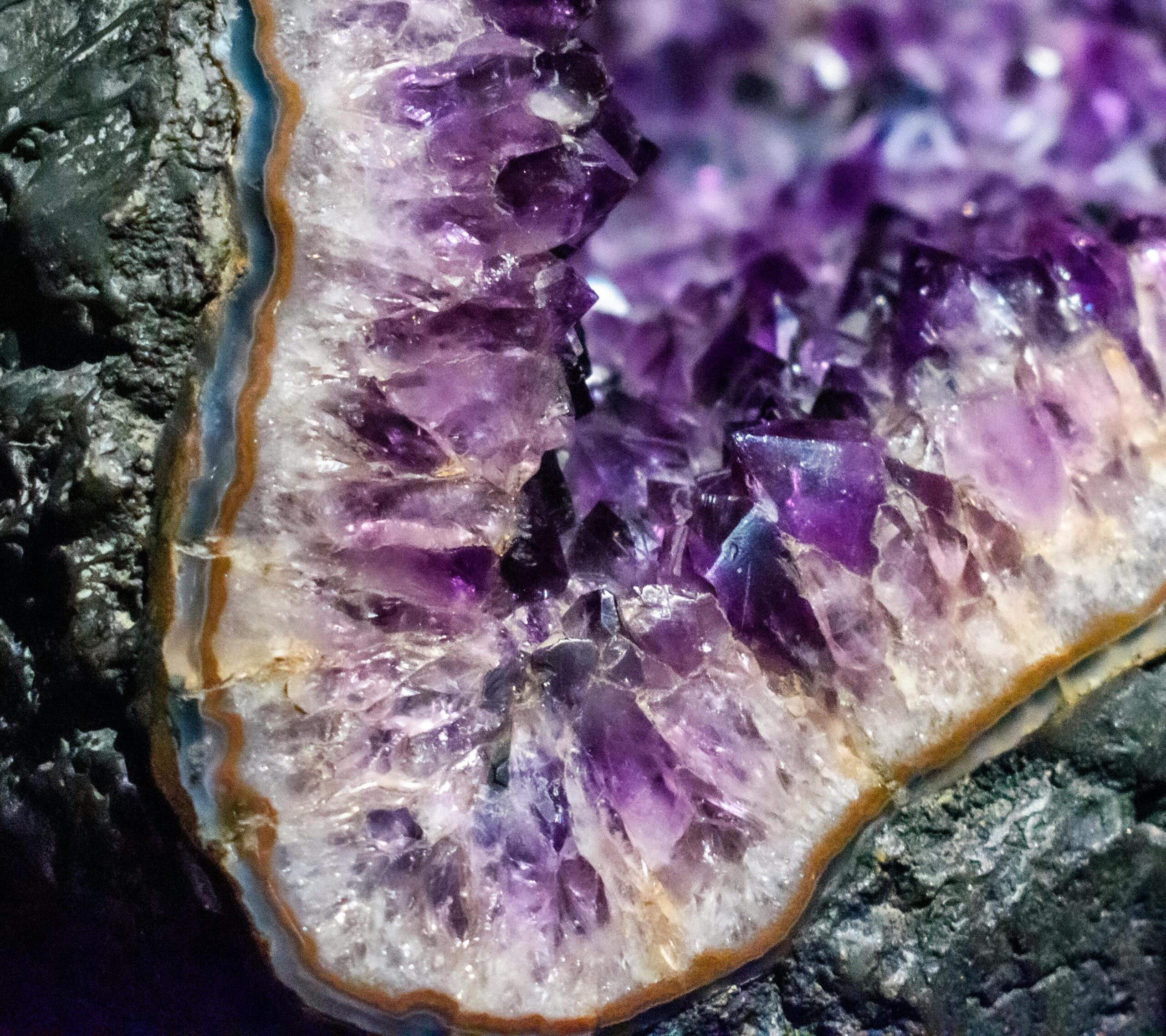 Amatista natural en geoda con cristales violetas brillantes sobre base rocosa